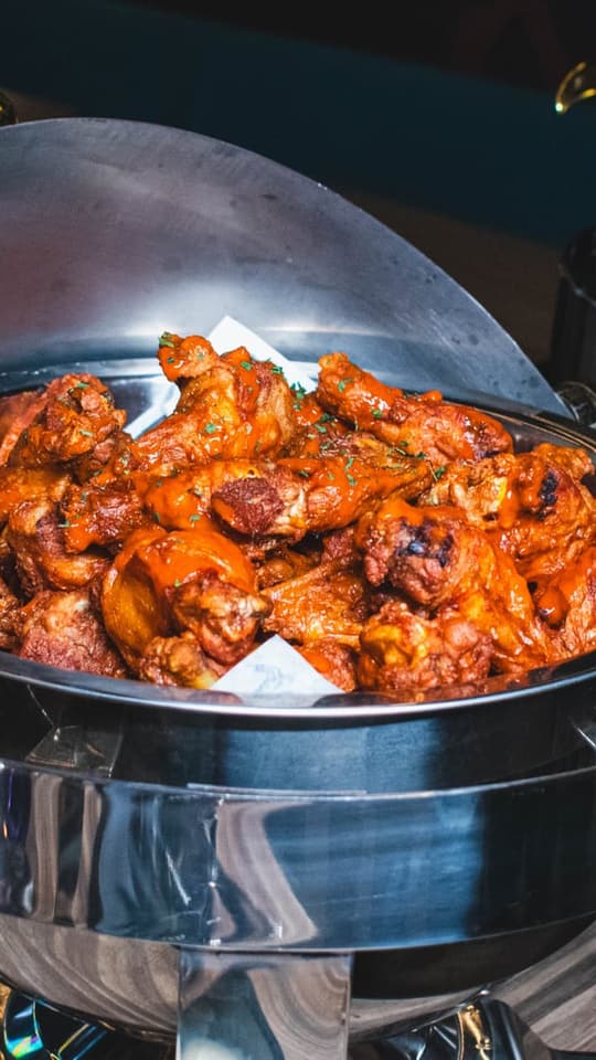 A platter of saucy wings on a chafer at Twisted Pin
